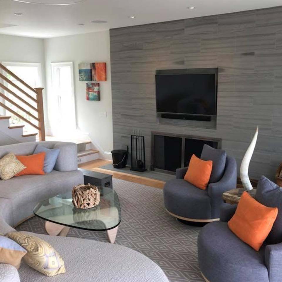 Modern living room with gray furniture, orange pillows—perfect for Custom Home Building projects.
